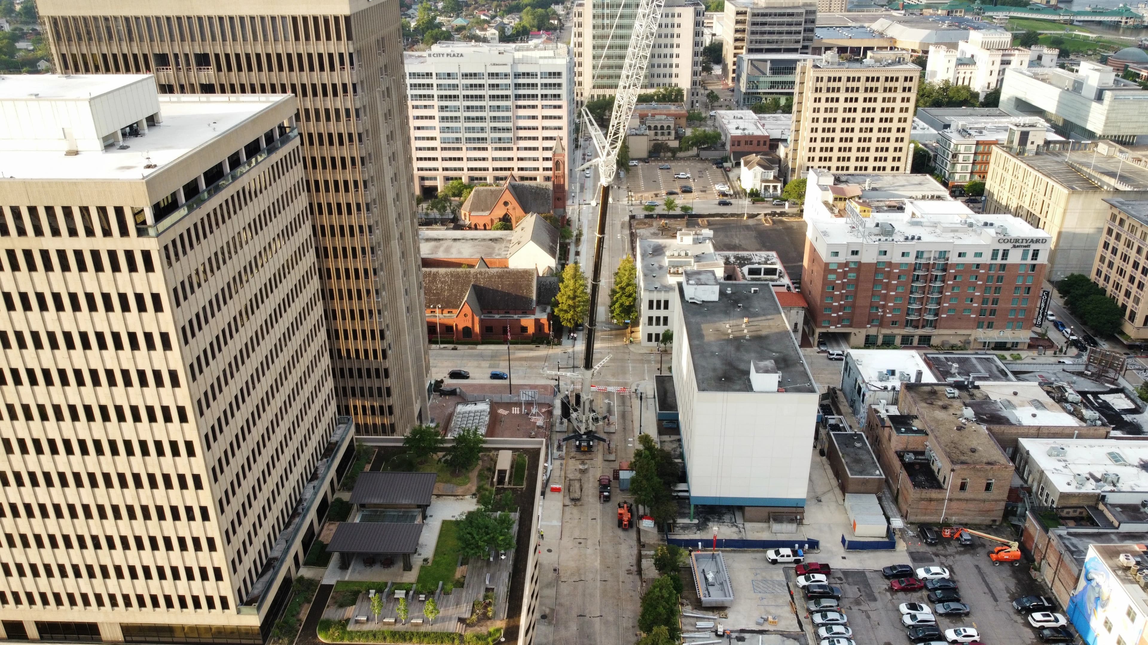 Crane built in middle of baton rouge down town moving a sign on a clear day